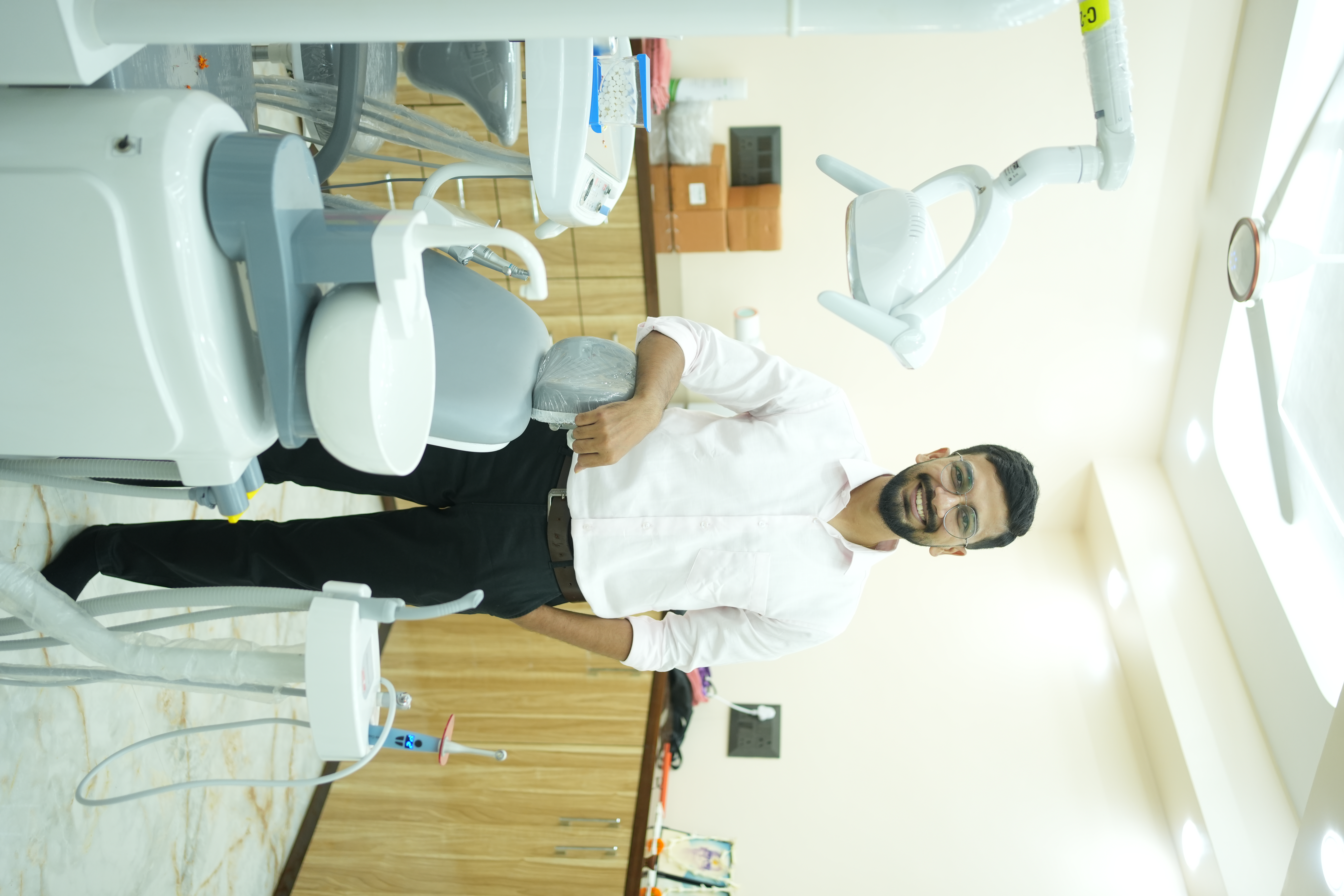A man in a dental chair during a checkup with a professional dentist using a mirror.