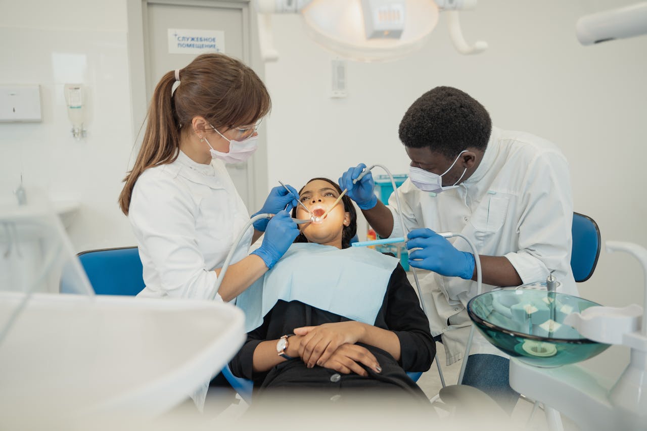 The Art of Drawing Readers In: Your attractive post title goes here Two dental professionals treat a patient in a modern clinic setting.